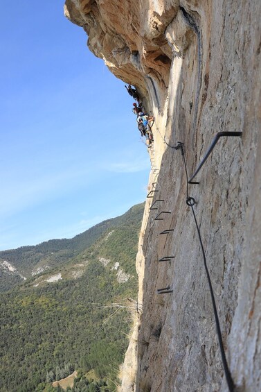 A person rappelling down a cliff with safety ropes and anchors. 2