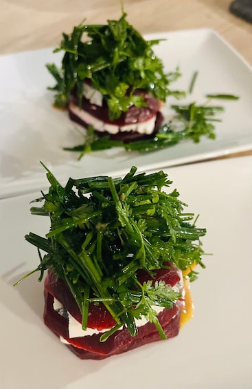 A dish with arugula and a red center, possibly beetroot, on a white plate. 5