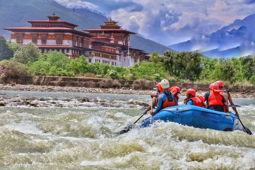 A group rafting on a river with a traditional building in the background. 2
