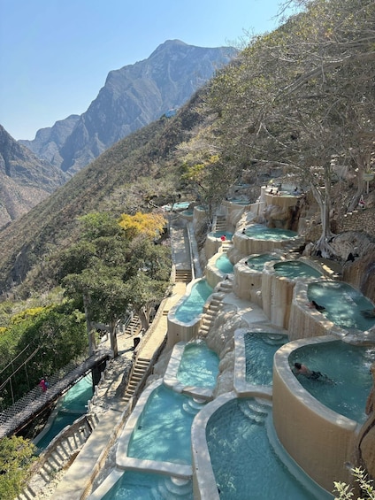 Terraced hot springs in a mountainous area with clear skies. 1