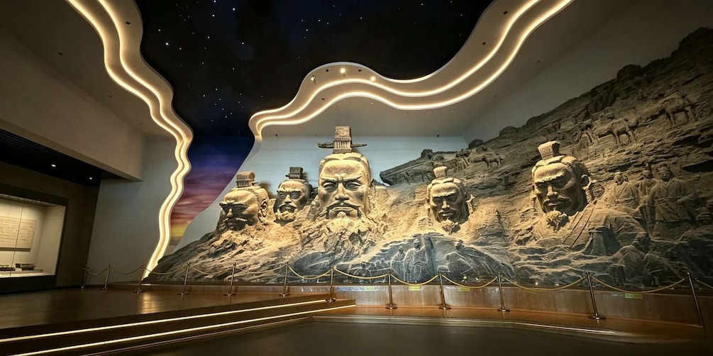 A museum interior with a large rock relief sculpture, a starry ceiling, and a modern light design. 1