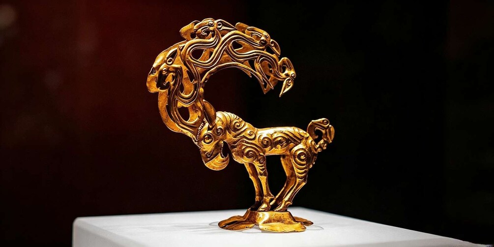 A golden sculpture of a horse with intricate designs. 2