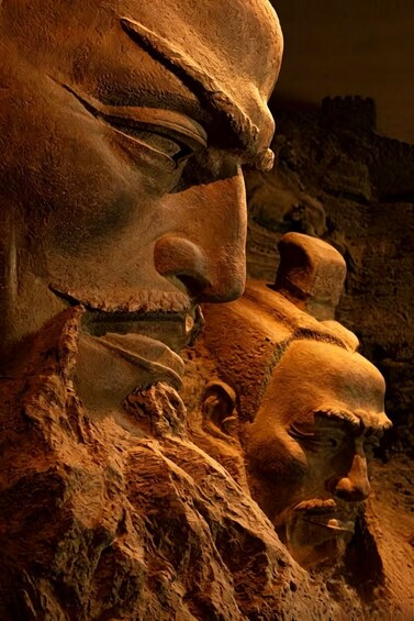 A close-up of a stone sculpture with a prominent nose and a partially visible eye. 1