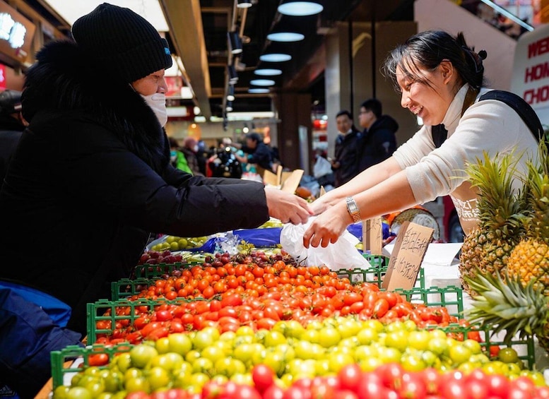 A market scene with people buying and selling fruits and vegetables. 4