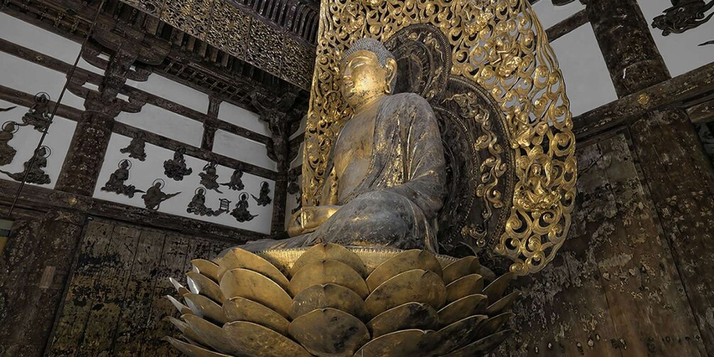A large golden Buddha statue with intricate carvings, surrounded by ornate decorations and smaller statues. 1