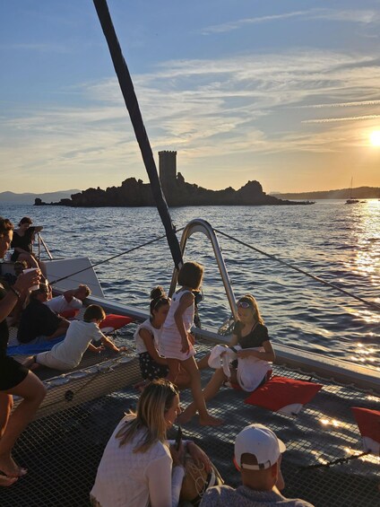 A group of people on a boat with a castle in the background during sunset. 2