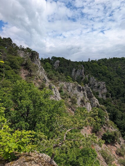 A mountainous landscape with dense green foliage and rocky cliffs. 5