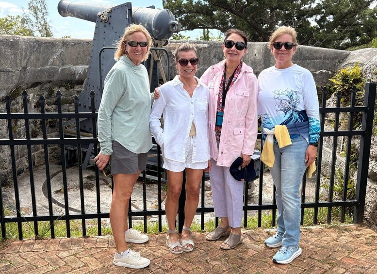 Four people standing in front of a cannon. 4