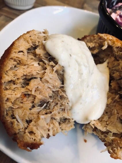 A slice of bread with a creamy sauce on a white plate. 3