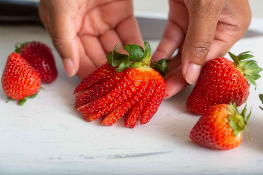 Hands holding and examining strawberries. 2