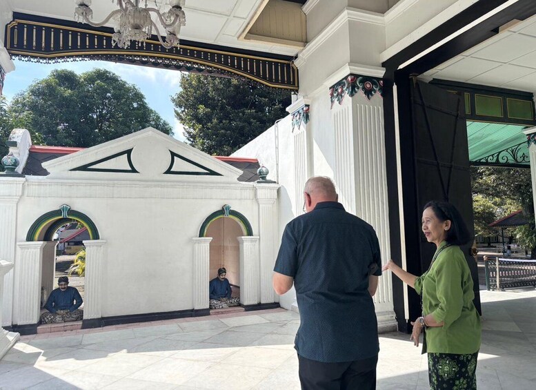 A white building with green and yellow arches, a black and white striped awning, and a chandelier. 5
