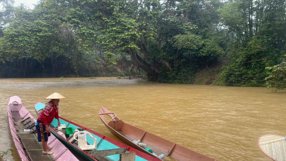 A river with boats and a person in a conical hat. 2