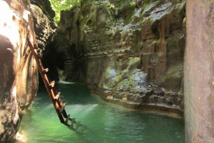 A narrow canyon with a chain over a water channel. 5