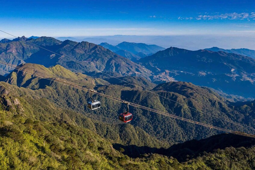 A cable car system in a mountainous area with lush greenery and distant peaks. 4