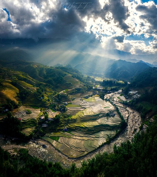 Terraced rice fields, a river, and mountains under a cloudy sky. 5