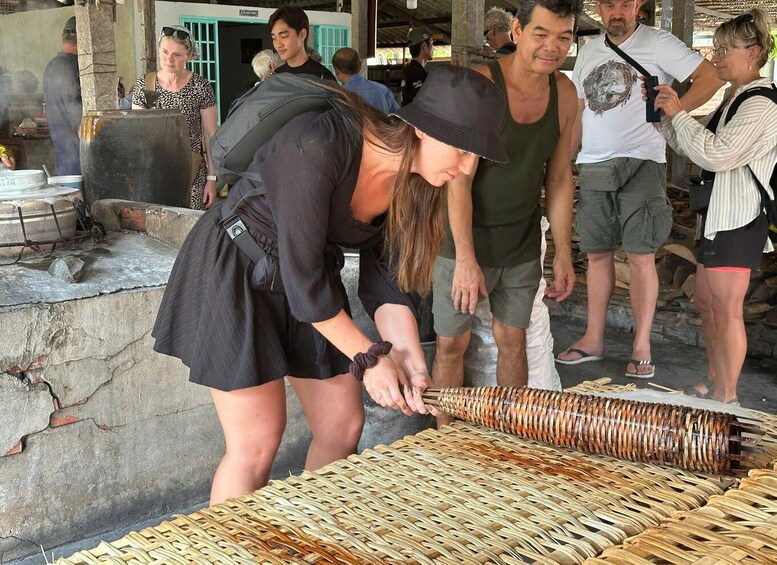 A person handling a large woven basket on a stone surface. 1