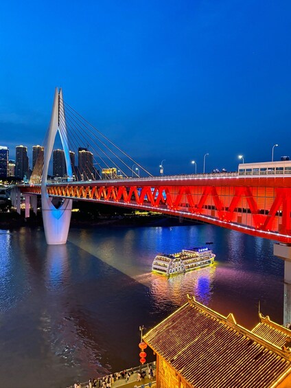 A lit bridge with a boat on the water. 4