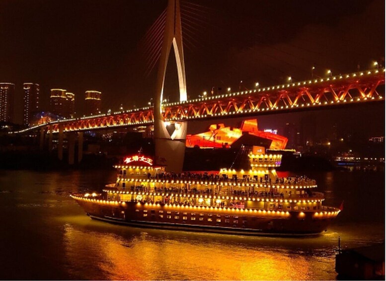 A river cruise ship with illuminated decks and a bridge in the background. 5