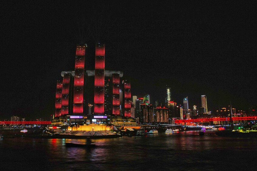 A nighttime cityscape with illuminated skyscrapers and a river. 3