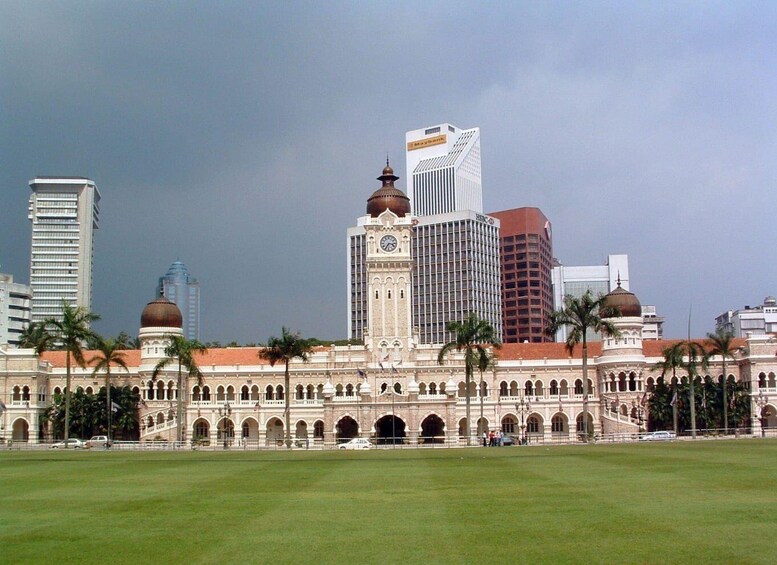 A historic building with domes and arches, surrounded by palm trees and modern skyscrapers. 2