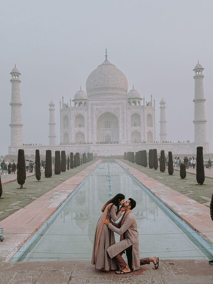 A couple kissing in front of the Taj Mahal. 3