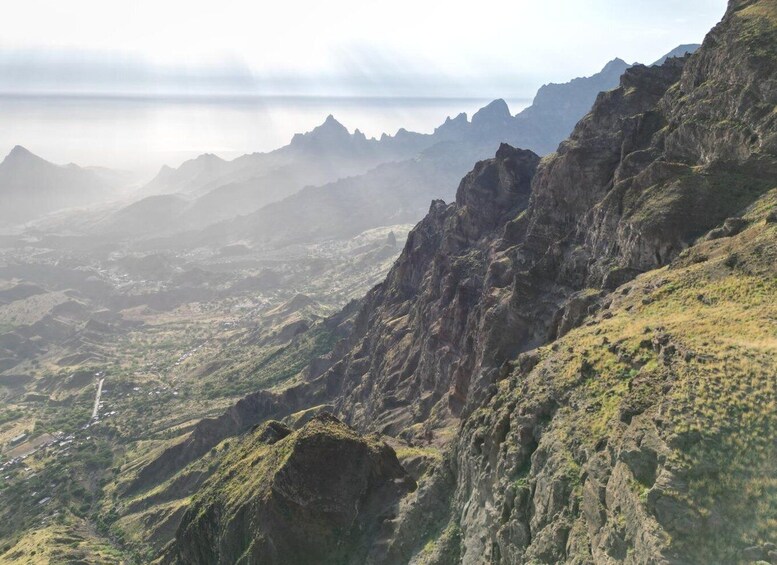 A mountainous landscape with rugged terrain and a winding road. 1
