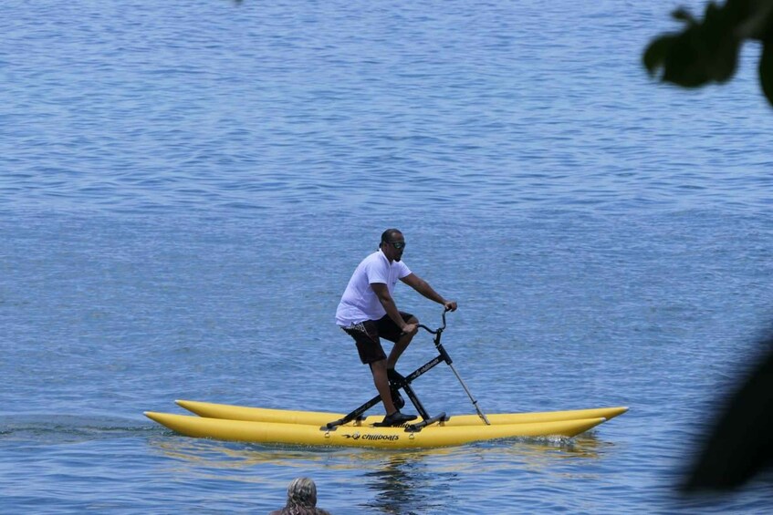 A person riding a yellow paddleboard on calm water. 3