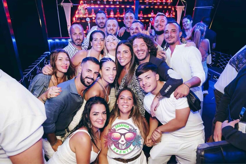 A group of people at a party with a banner that reads 'SARANDA EVENTS'. 3