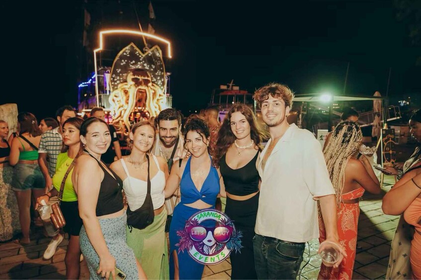 A group of people at an outdoor event with a large illuminated structure in the background. 2
