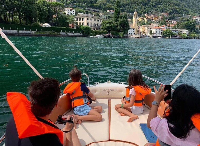 A boat with people wearing life jackets, a town with buildings and a tower in the background. 2
