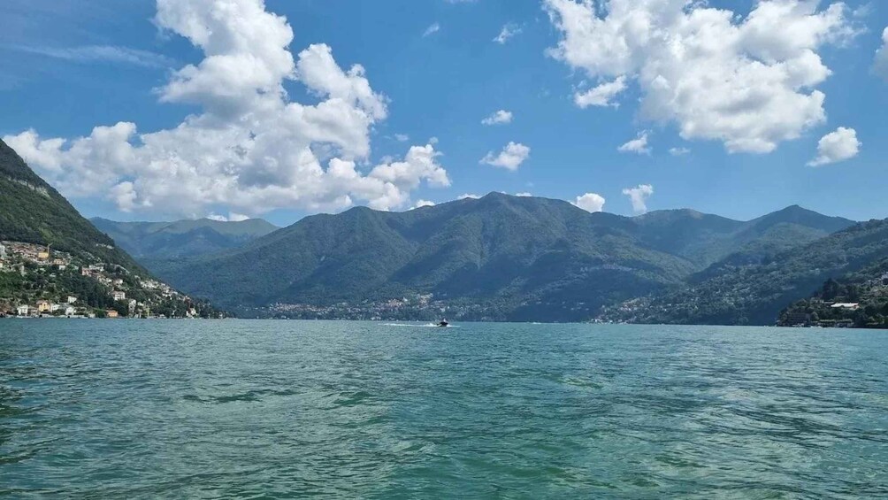 A lake with mountains in the background and a small boat on the water. 3