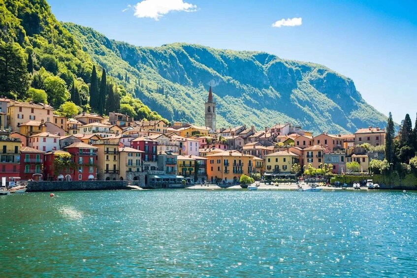 A coastal town with colorful buildings, a church tower, and a mountain backdrop. 4