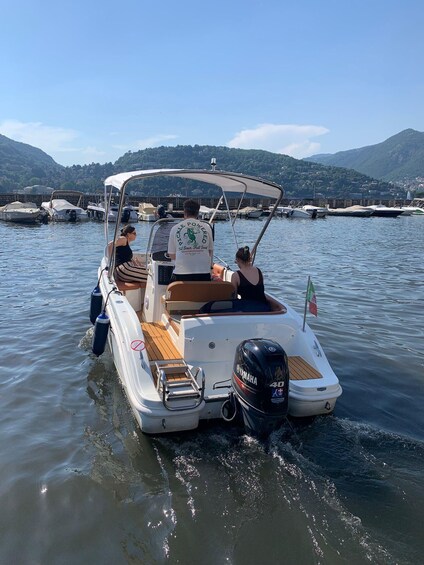 A small motorboat with a canopy, a Yamaha outboard motor, and a flag on the back. 5
