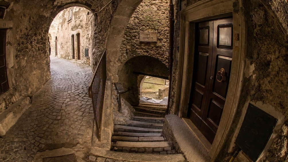 A stone staircase leading to a door with a sign above it. 3
