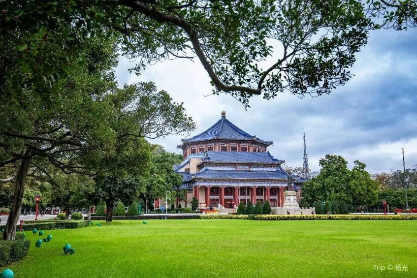 A traditional Chinese building with a blue roof and red walls, surrounded by a well-maintained lawn and trees. 5
