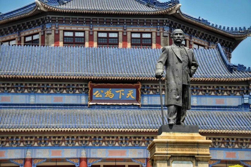 A traditional building with a tiled roof and a statue in front. 3