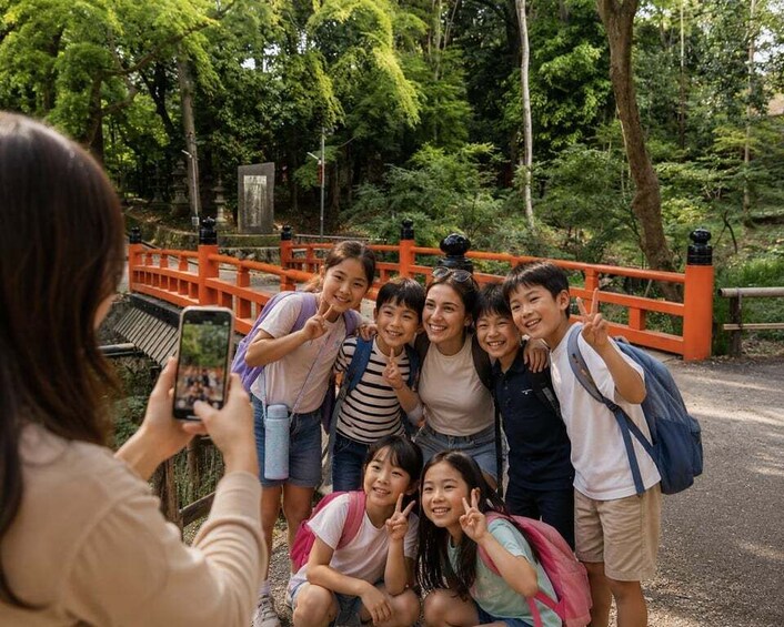 A group of people posing in front of a bridge with a stone monument. 2