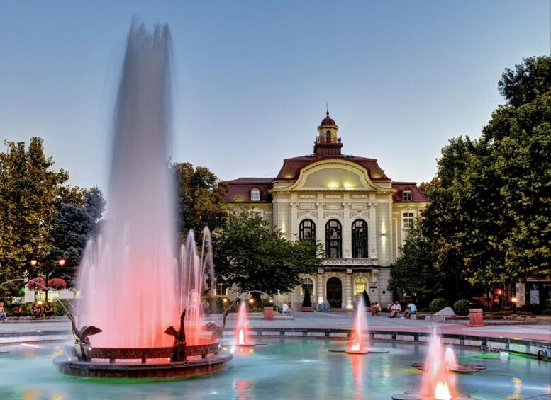 A grand building with a dome and a fountain with multiple jets in front. 5