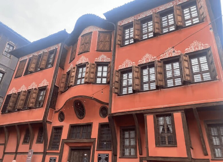 A multi-story building with ornate wooden shutters and a curved facade. 2