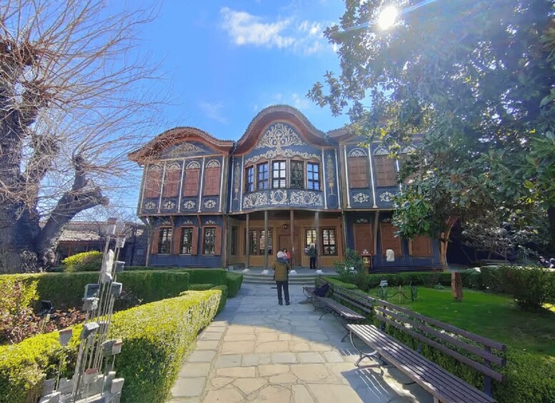 A large, ornate building with intricate architectural details, surrounded by a well-maintained garden with benches and a clear pathway. 4