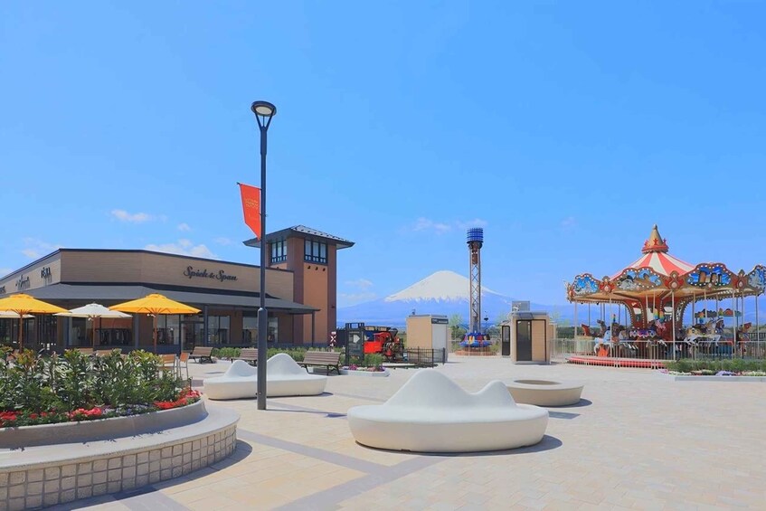 A plaza with a Spick & Span building, a carousel, and a mountain in the background. 3