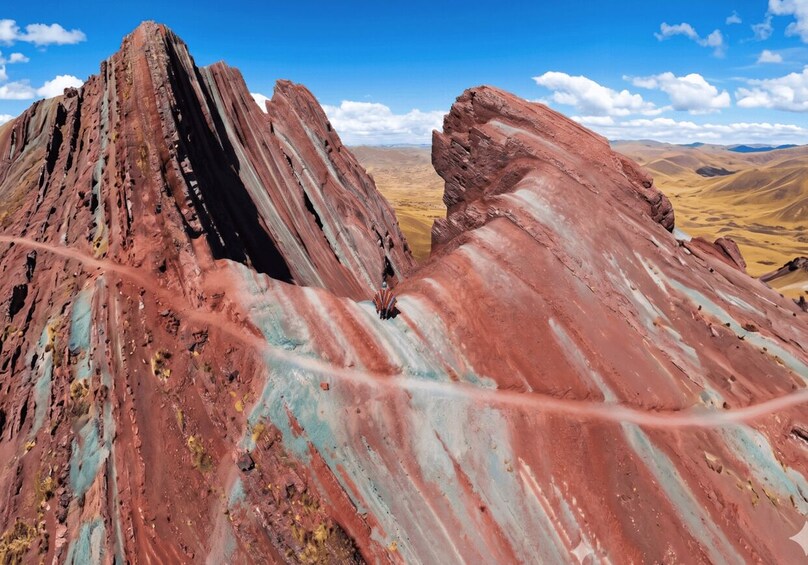 A rugged mountain landscape with prominent red and pink rock formations. 1