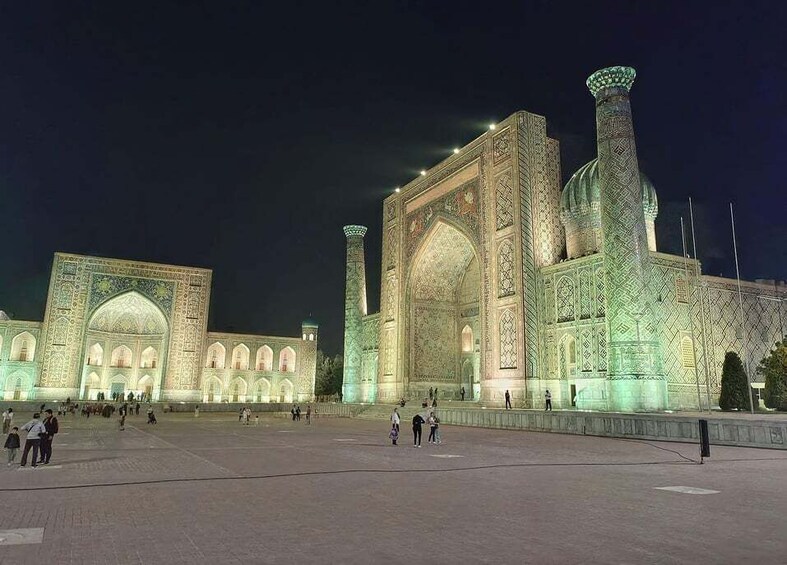 A large, illuminated mosque with intricate tile work and multiple domes. 3