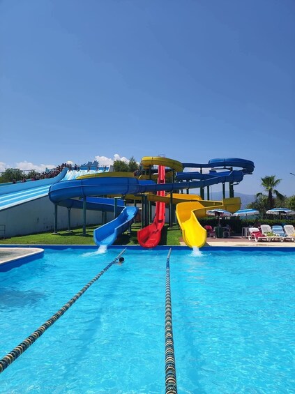 A swimming pool with multiple water slides and lounge chairs. 2