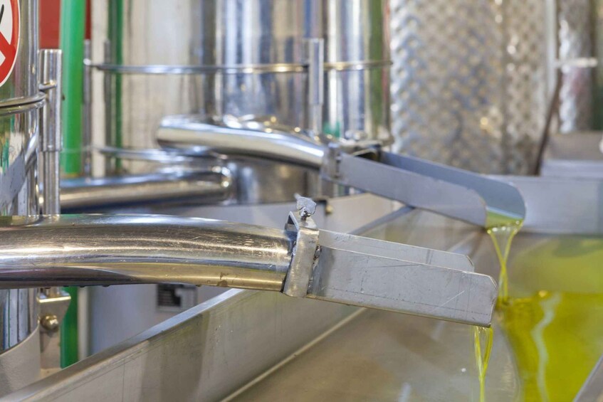 A stainless steel industrial setup with a yellow liquid flowing through a pipe. 2