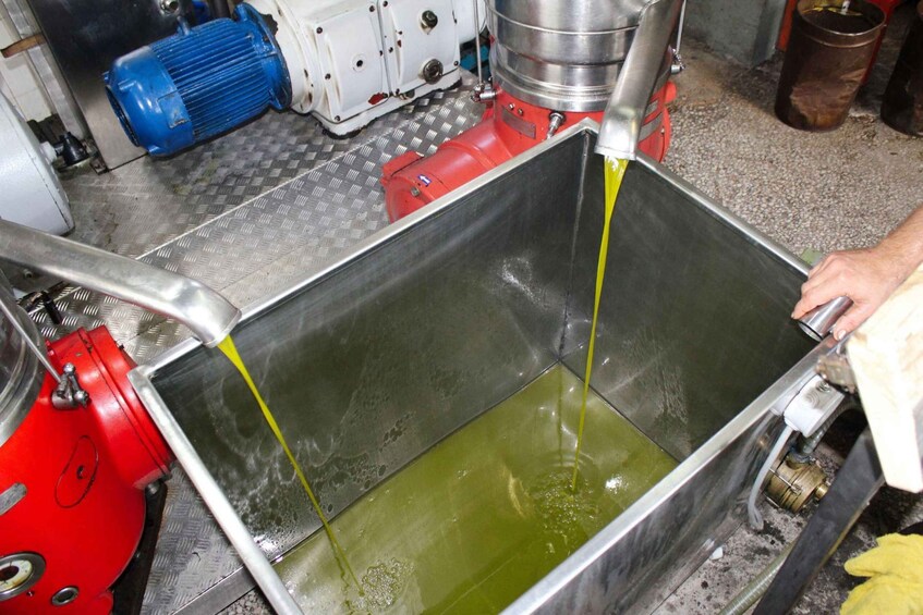 A metal container with green liquid being poured from a red machine. 5