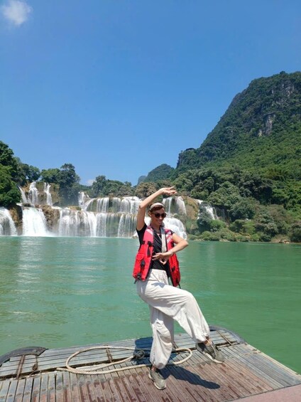 A person on a wooden dock with a waterfall in the background. 5