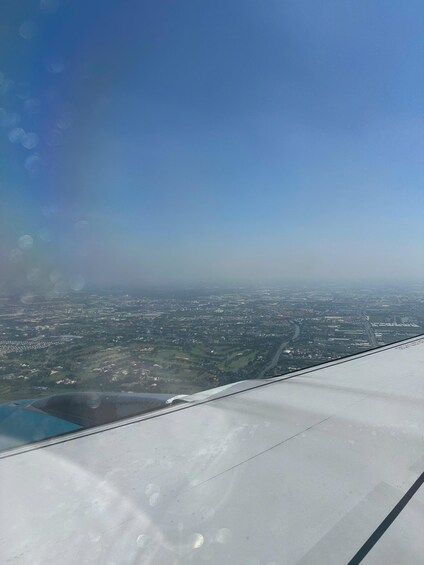 An airplane wing with a cityscape below. 4