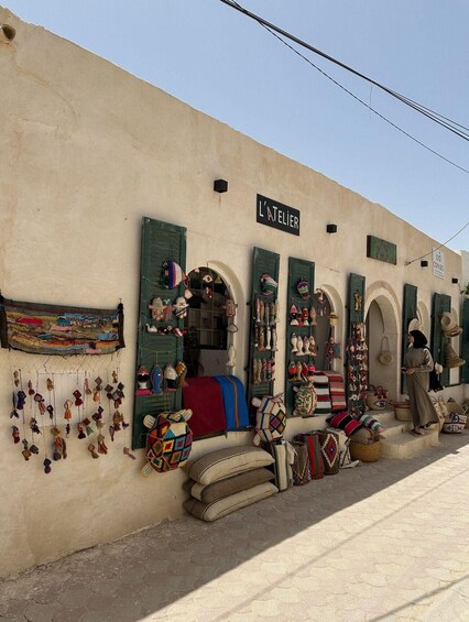 A shop named 'L'Atelier' with various handicrafts displayed outside. 2