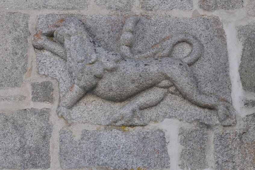 A stone carving of a mythical creature on a wall. 4